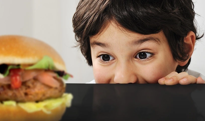 Child watches with appetite a savoury bomba