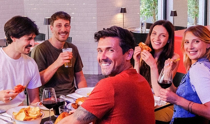 Gruppo di amici che si gode un aperitivo all'inerno di un ristorante ALT