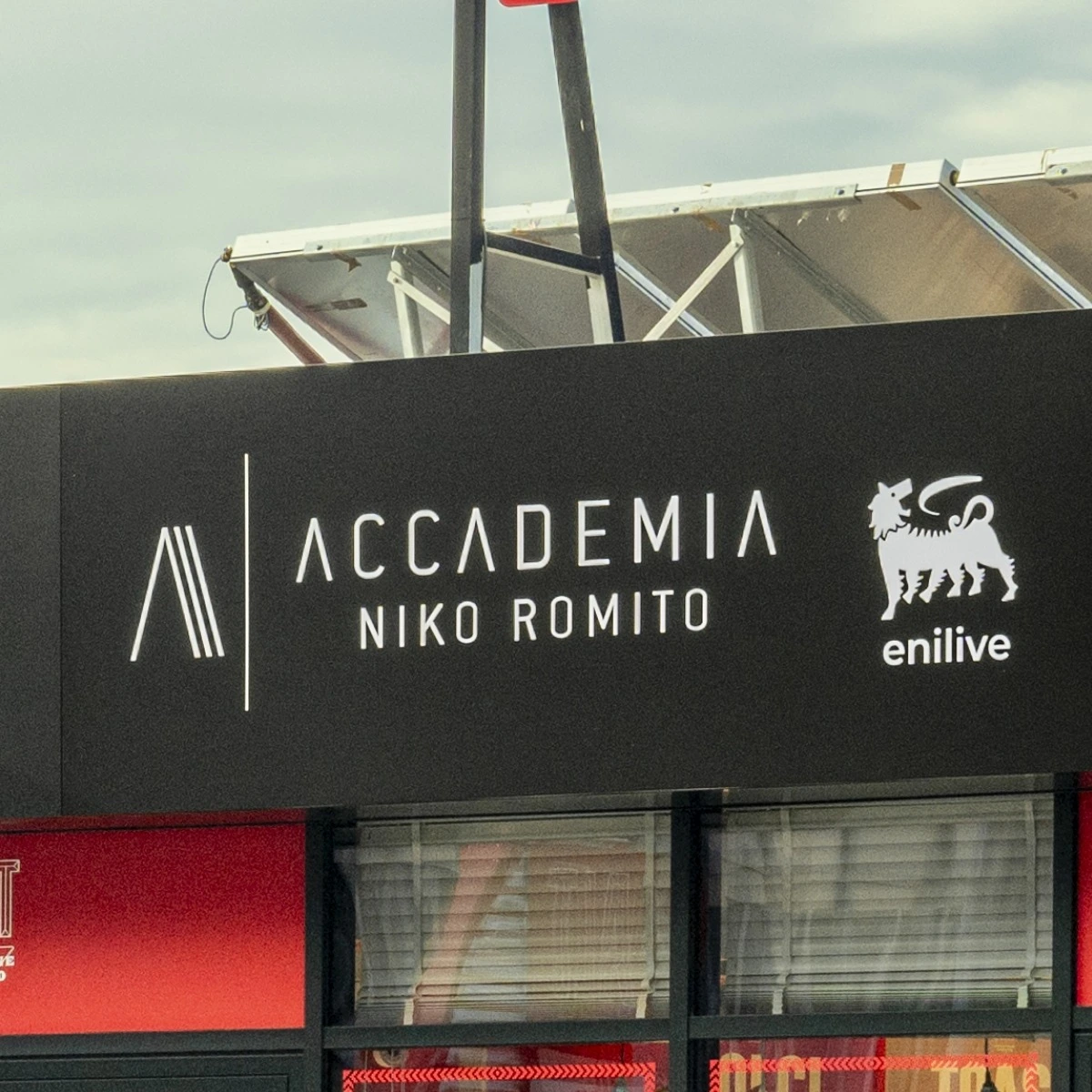 Niko Romito Academy (Accademia Niko Romito) and Enilive logos on ALT store sign