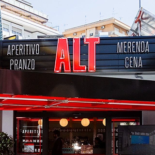 Façade and entrance door of an ALT Stazione del Gusto store with signage